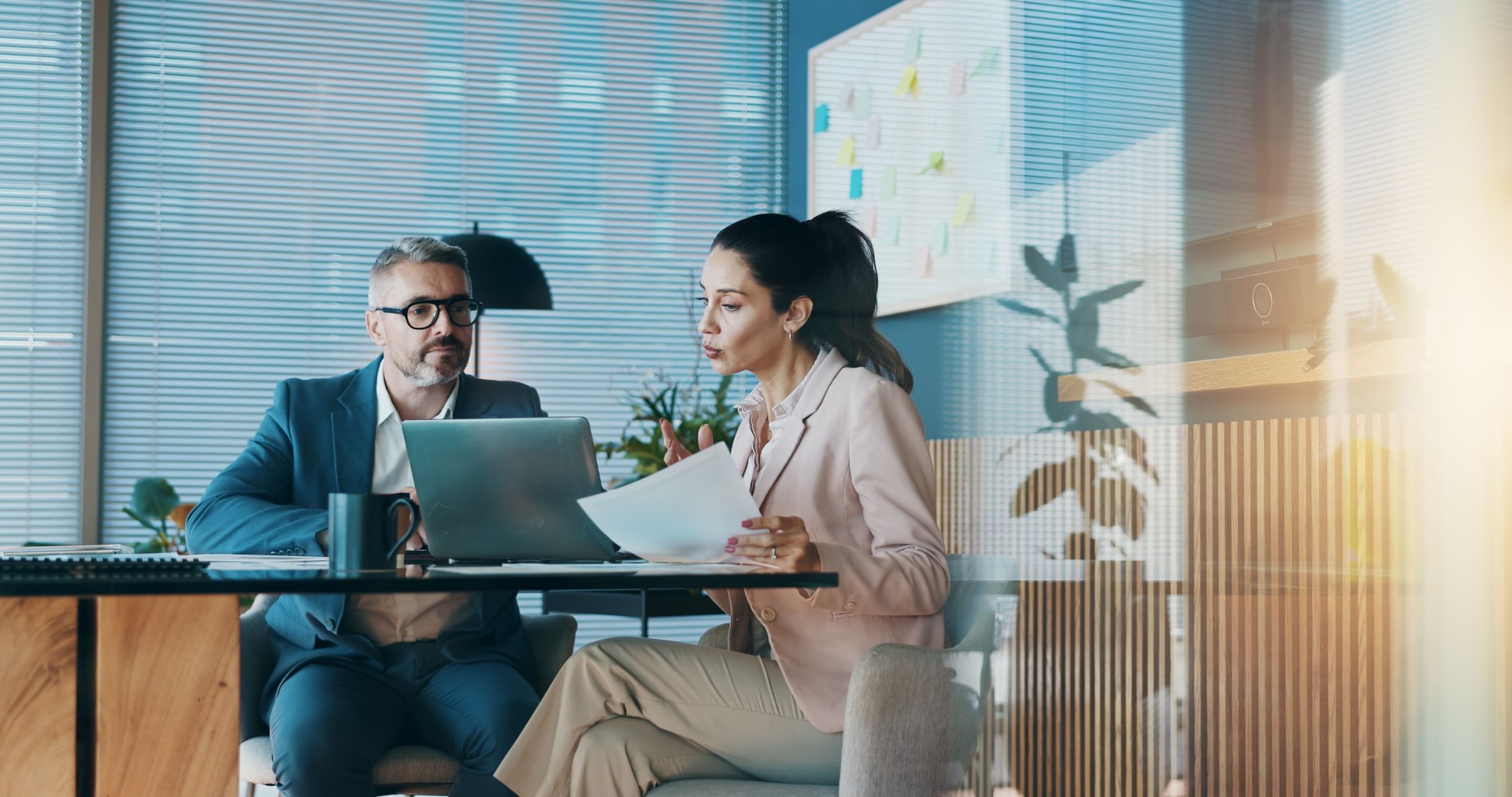 Paperwork, laptop and business people in office with meeting for company investment deal. Computer, documents and finance manager with investor client for discussion with dividend report in workplace